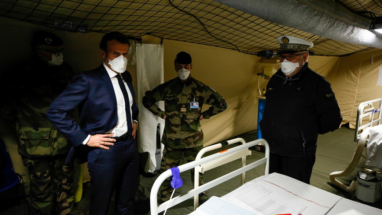 Un homme et des soldats portant des masques.