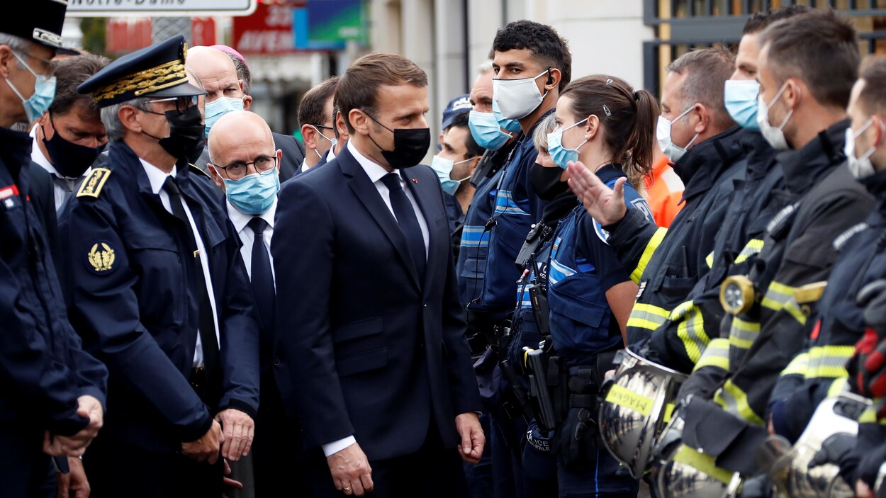Le président Macron discute avec des policiers.