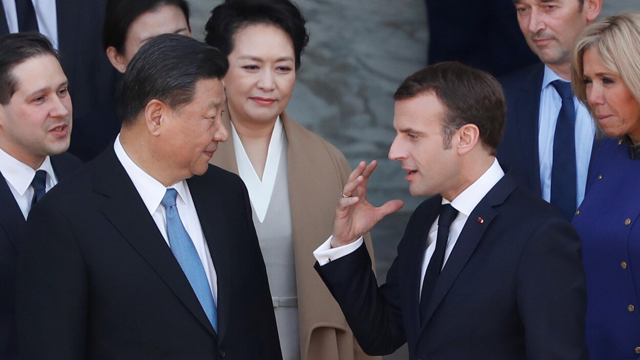 Xi Jinping et Emmanuel Macron discutent sous le regard de leurs épouses et d'autres diplomates.
