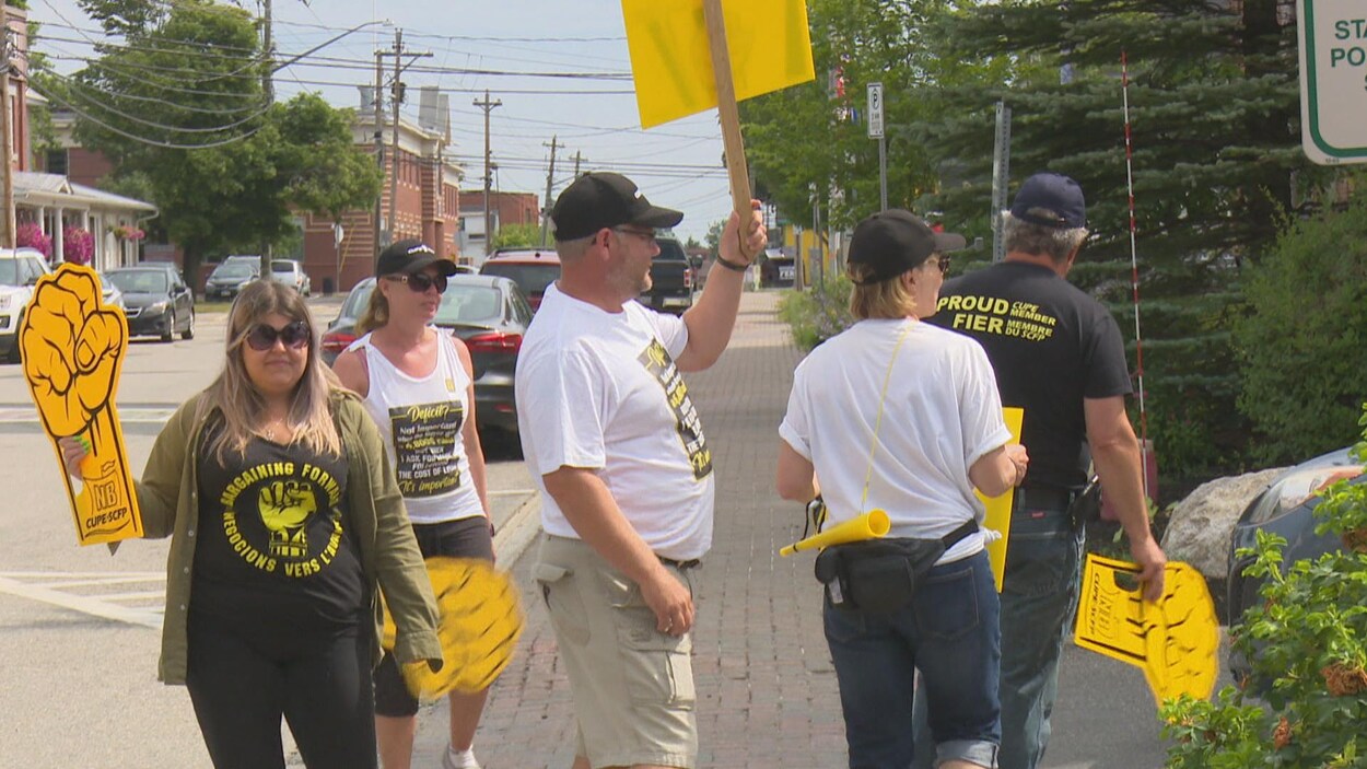 Des employés manifestent devant l'hôtel de ville.