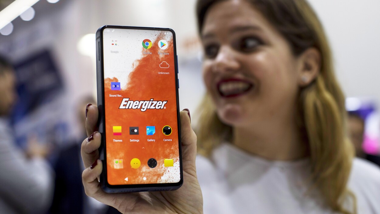 Une photo d'une femme qui tient un téléphone Power Max P18K dans sa main.