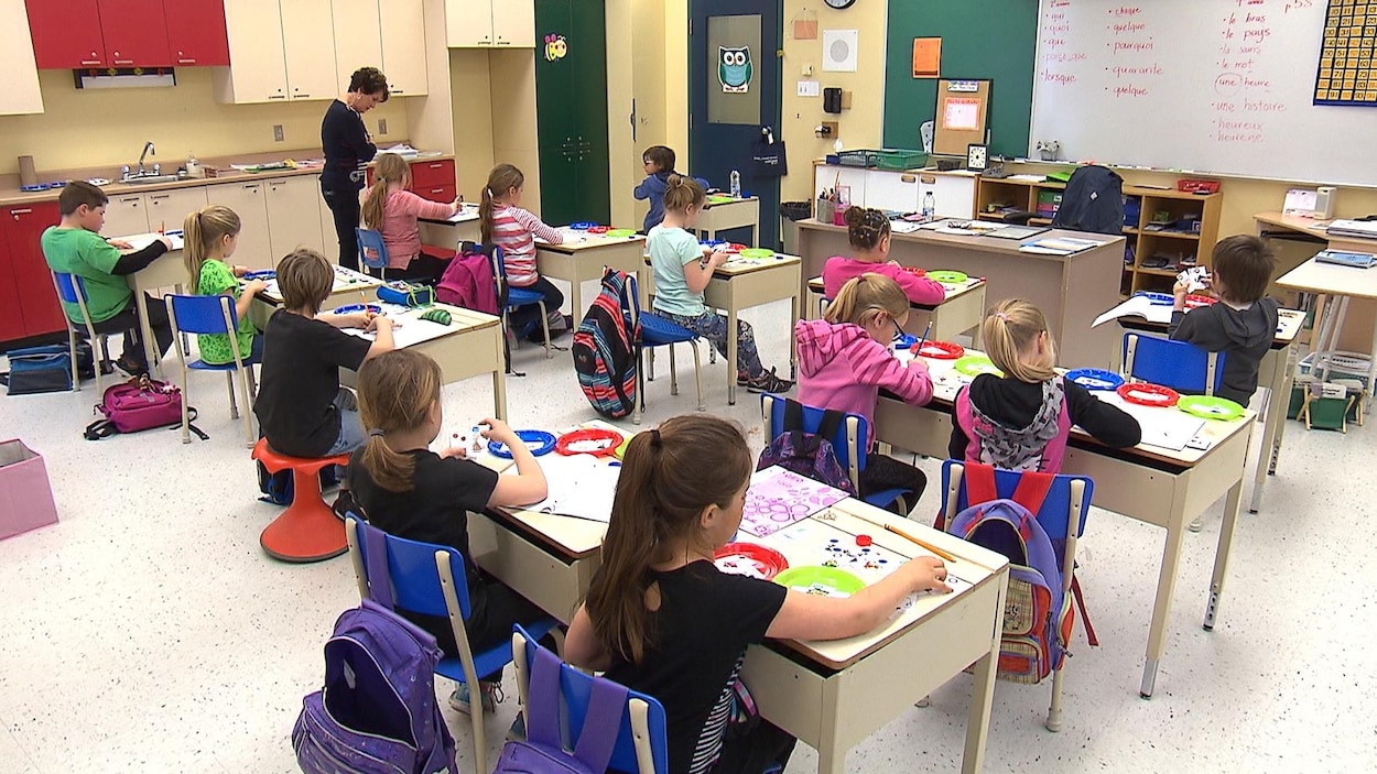 Une vingtaine de jeunes enfants assis dans une classe Une vingtaine de jeunes enfants assis dans une classe