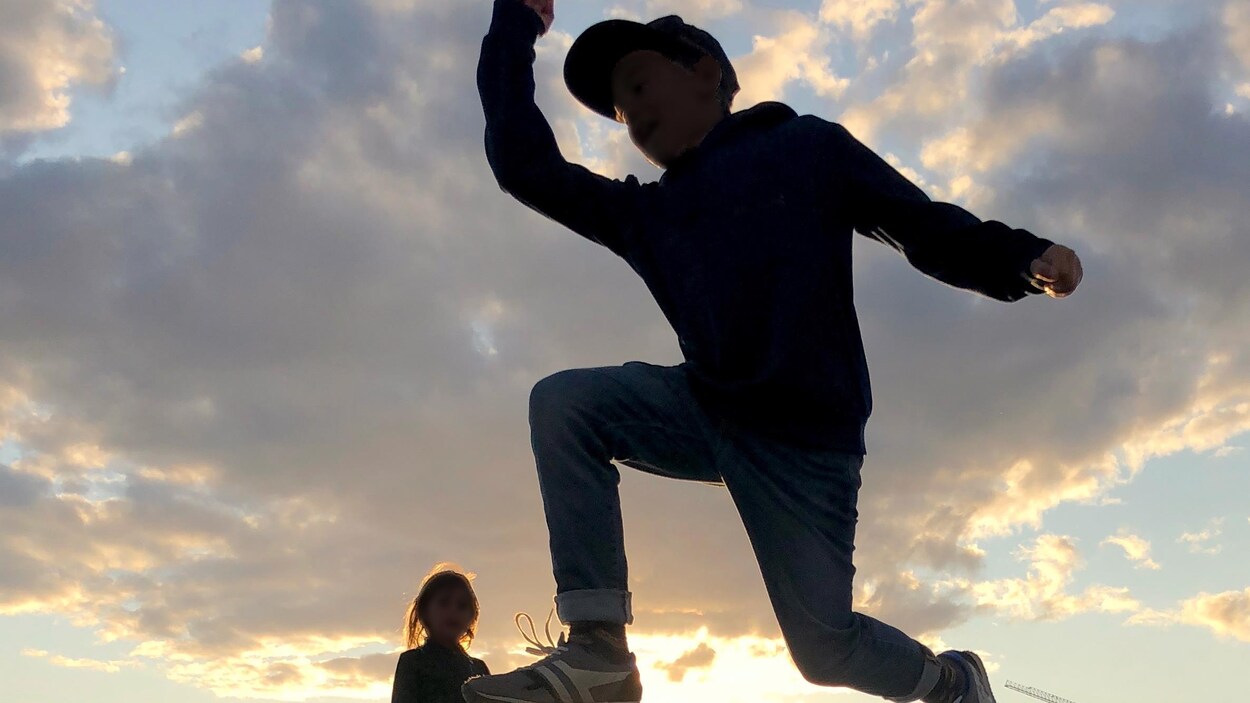 Des enfants jouent et un couple danse au parc Zaryadye, à Moscou, alors que le soleil se couche.