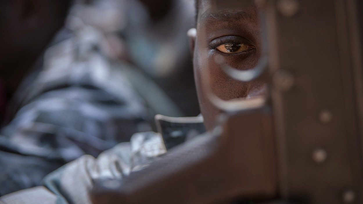 Gros plan sur le visage d'un enfant-soldat sud-soudanais récemment libéré qui regarde droit devant lui, le regard éteint.