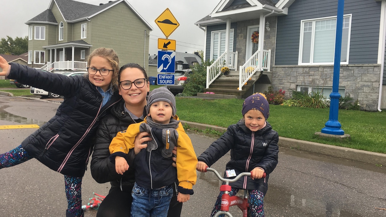 Laurie Fortin et ses enfants devant leur maison.