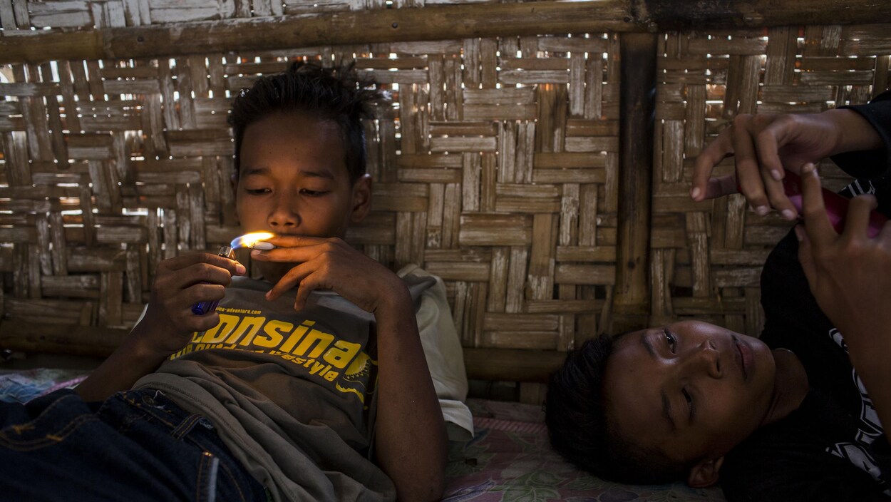 Un enfant allume une cigarette