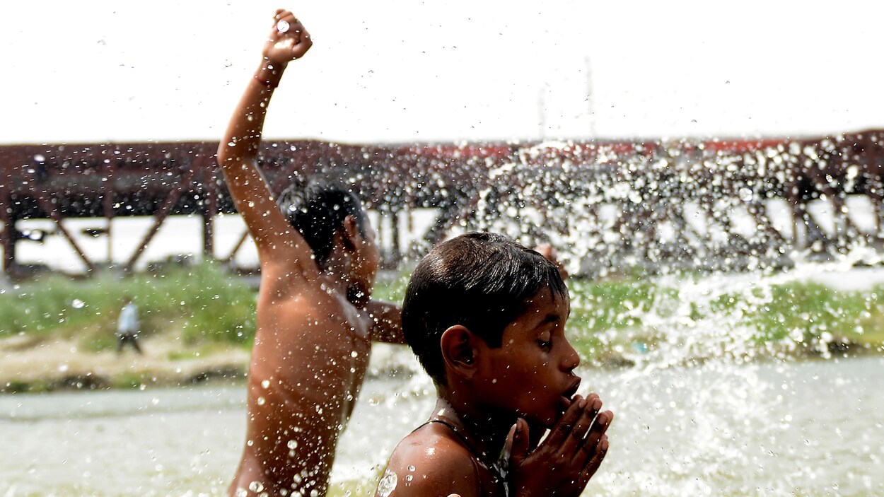 Des garçons indiens se baignent dans un lac.
