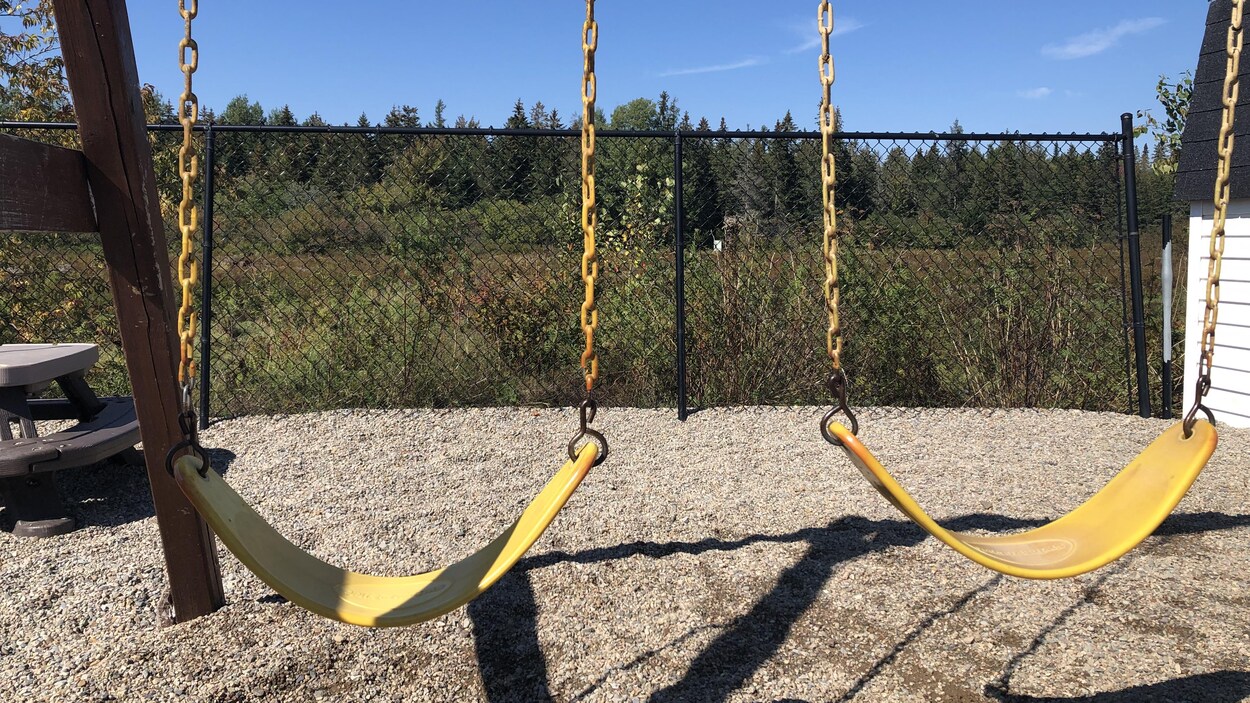 Deux balançoires jaunes sur un terrain de jeu.