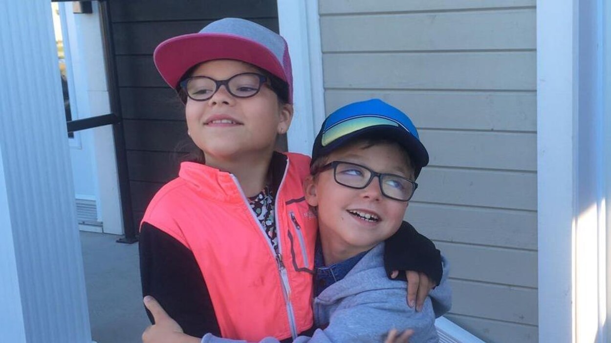 Kelly-Ann et Maël Thibault s'enlacent en souriant.