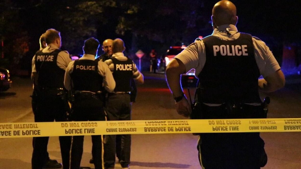 Un périmètre de sécurité devant des policiers. Un périmètre de sécurité devant des policiers.