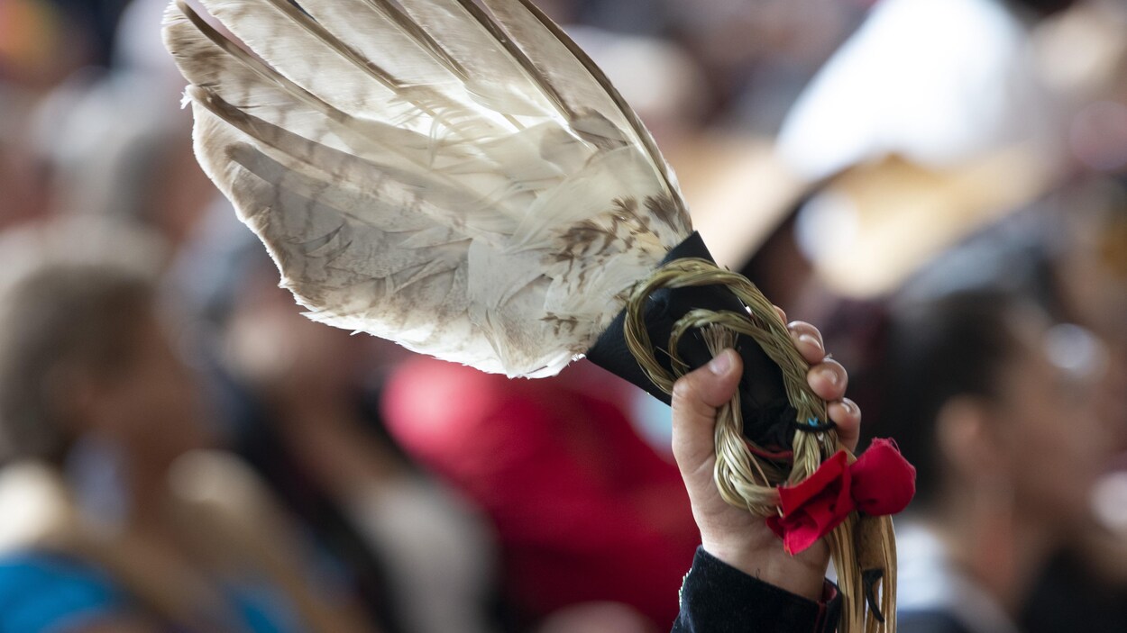 Un ruban rouge attaché à une plume d’aigle blanche a été levé dans les airs par un membre de l’assistance lors de l’événement.