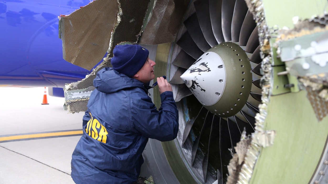Un enquêteur du Bureau américain de la sécurité des transports examine le moteur endommagé de l'avion de Southwest Airlines qui a atterri d'urgence à Philadelphie le 17 avril 2018. Un enquêteur du Bureau américain de la sécurité des transports examine le moteur endommagé de l'avion de Southwest Airlines qui a atterri d'urgence à Philadelphie le 17 avril 2018.
