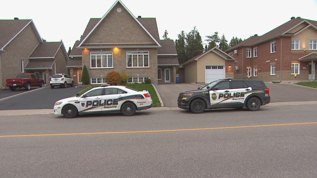 Deux véhicules de police devant la résidence.