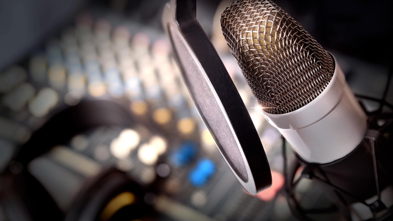 Un micro, des écouteurs et une table de mixage sonore.