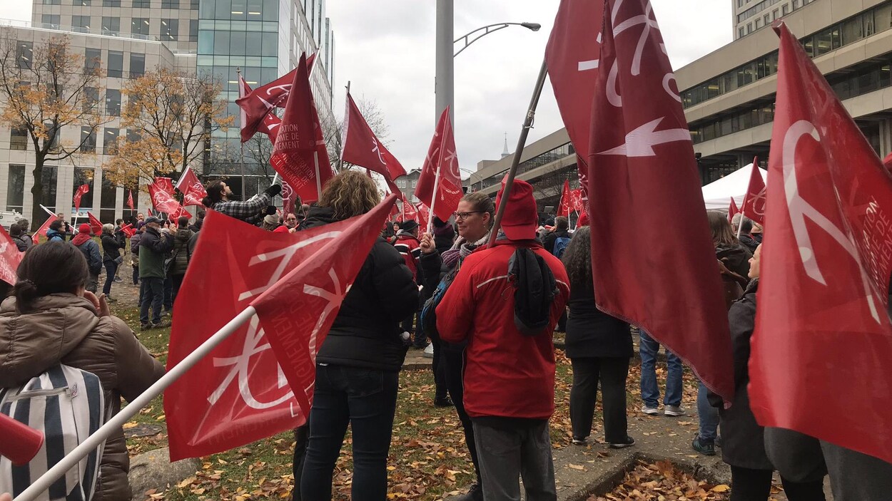 Des enseignants avec des drapeaux rouges manifestent.