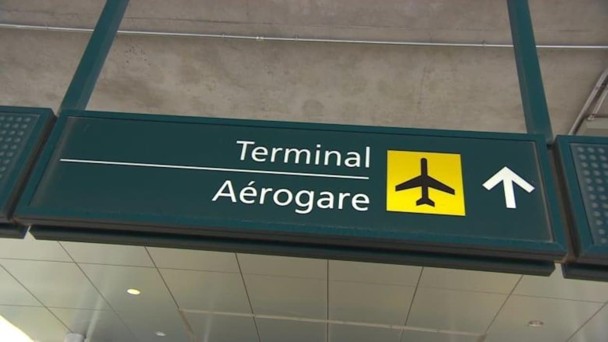 Un enseigne indiquant la direction de l'aérogare dans un aéroport.