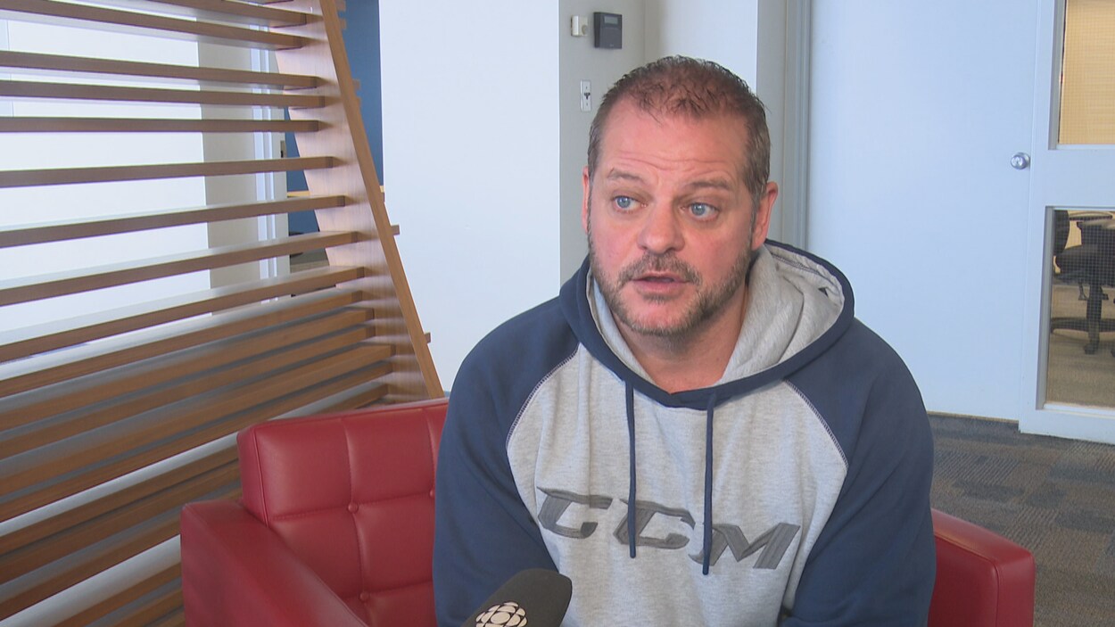 Portrait d'un homme assis qui répond à des questions lors d'une entrevue.