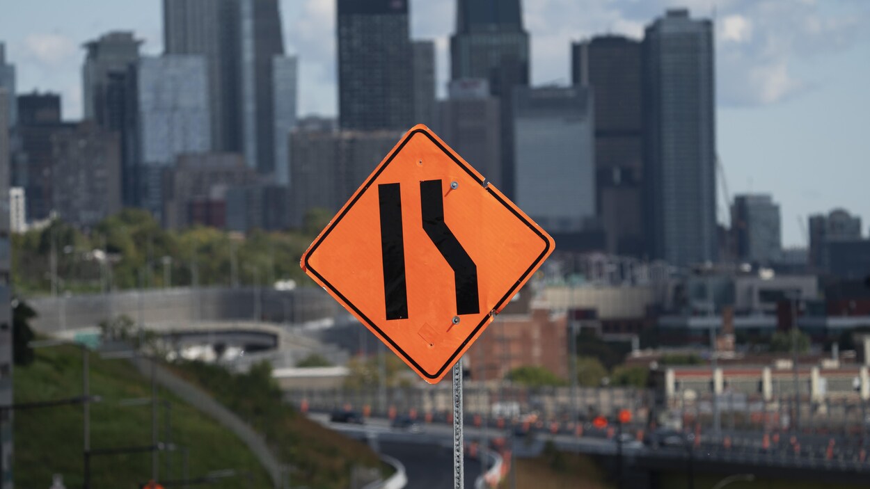 Un panneau de signalisation aux alentours de l’échangeur Turcot avec la vile de Montréal en arrière-plan.