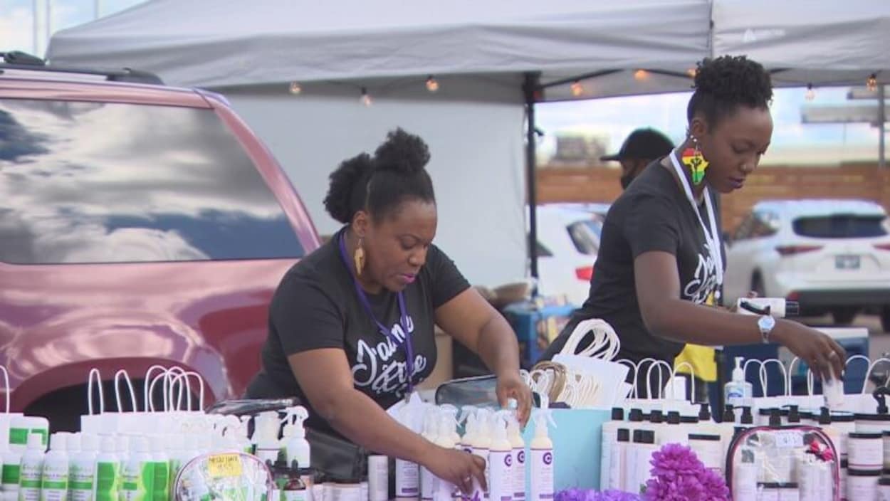 Deux femmes organisent une table remplie de produits de beauté.