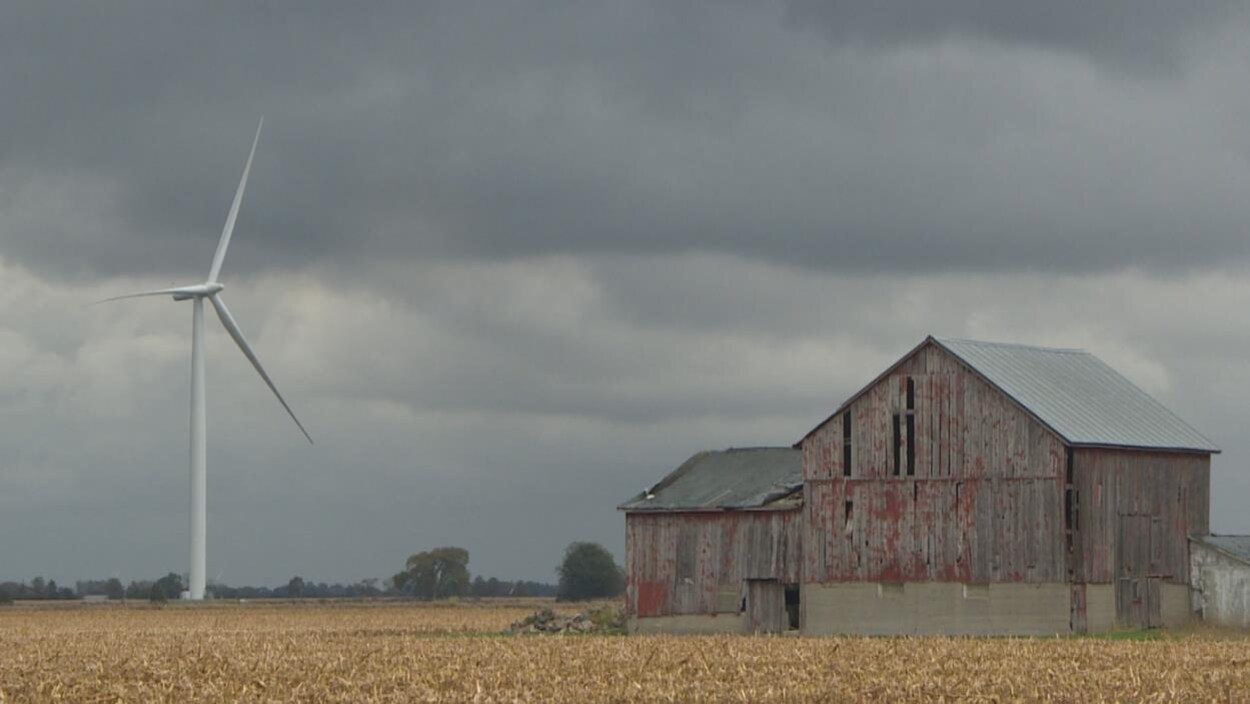 Une éolienne près d'une grange.
