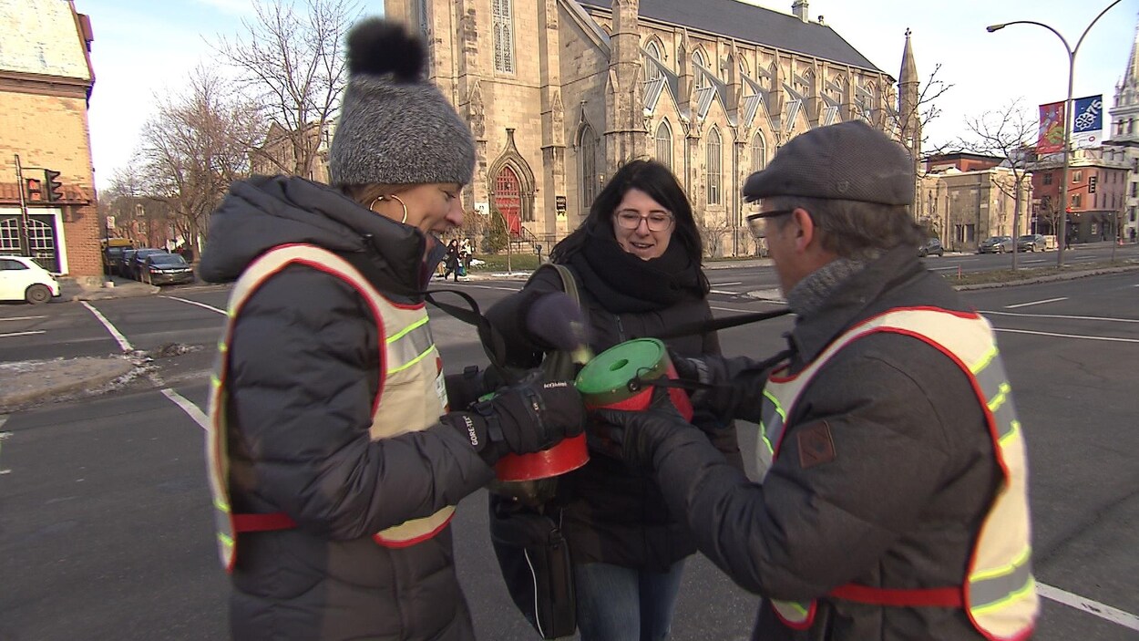 Une femme donne de l'argent pour la guignolée des médias Une femme donne de l'argent pour la guignolée des médias