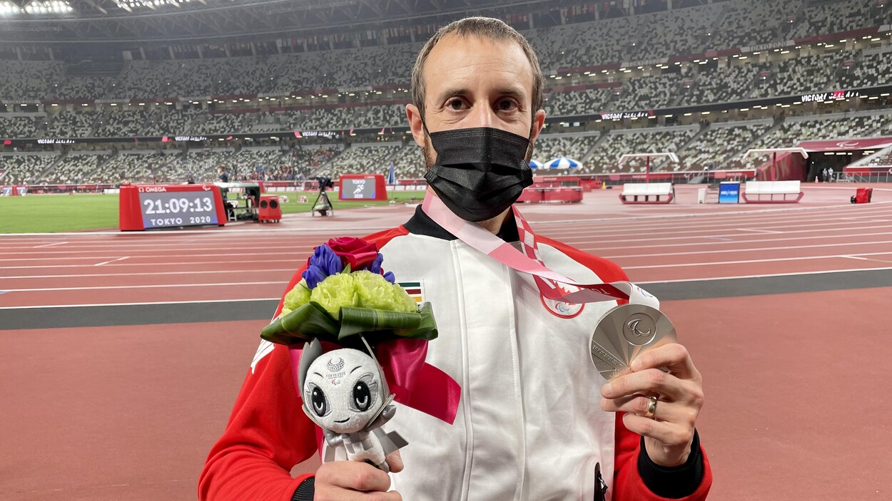 Brent Lakatos tient sa médaille d'argent et son bouquet.