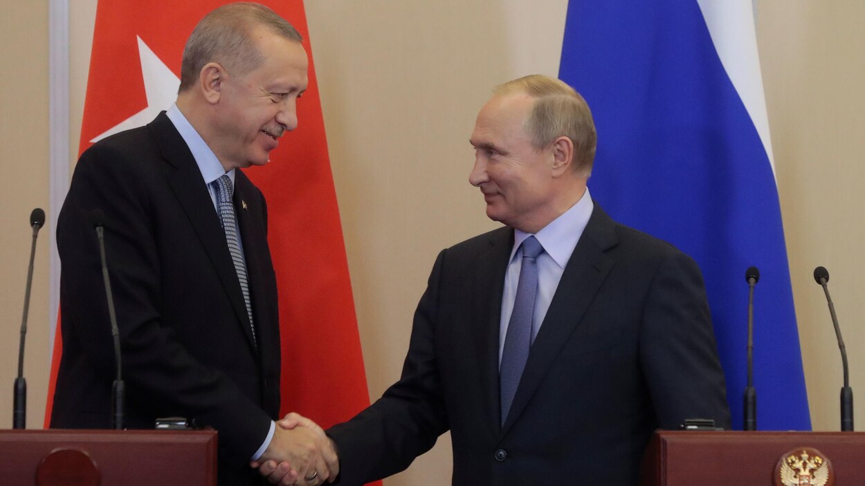 Recep Tayyip Erdogan et Vladimir Poutine se serrent la main.