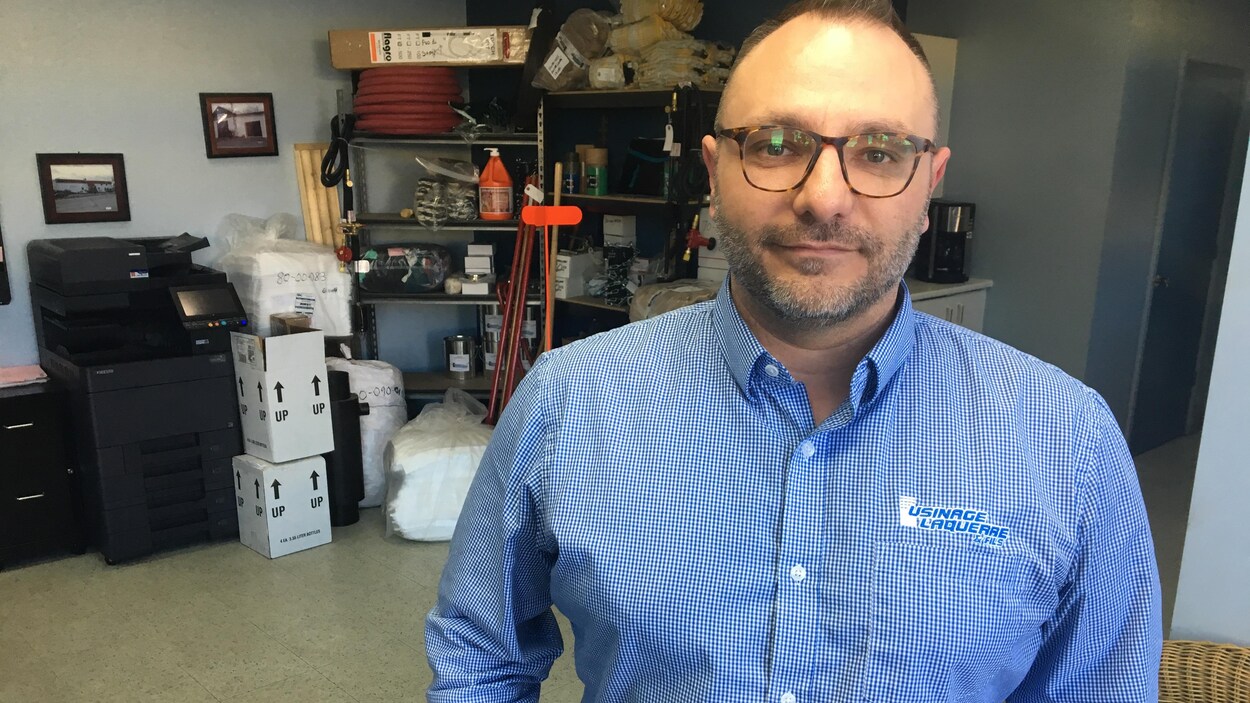 Un homme portant une chemise d'Usinage Laquerre pose pour la caméra.