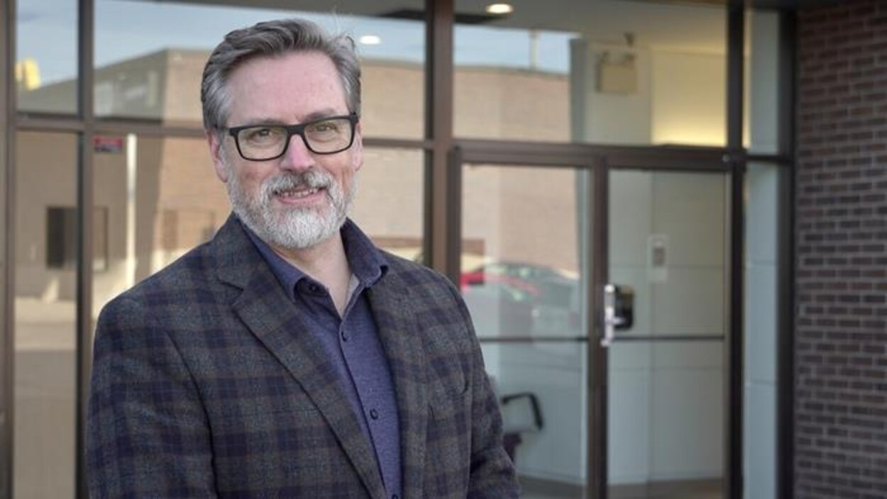 Le directeur général du Droit, Éric Brousseau devant le bâtiment où se trouve la salle de nouvelles.