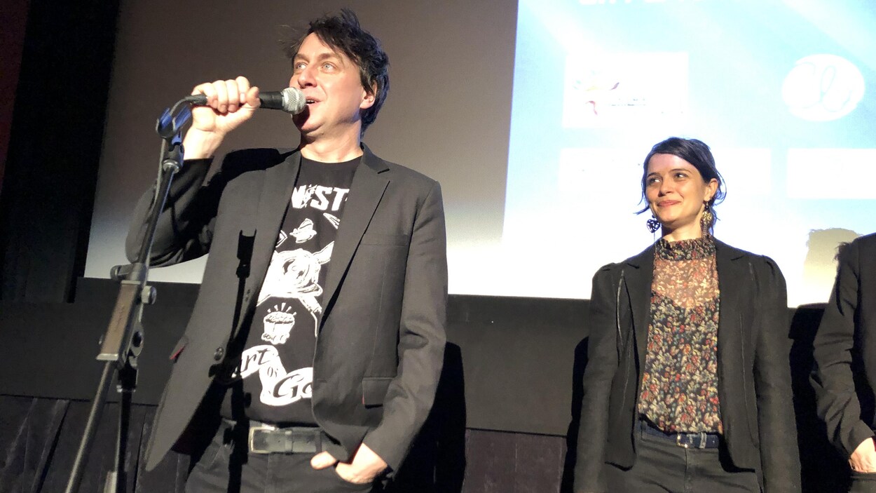 Éric Morin parle au micro dans une salle de cinéma, la comédienne Catherine de Léan à ses côtés.