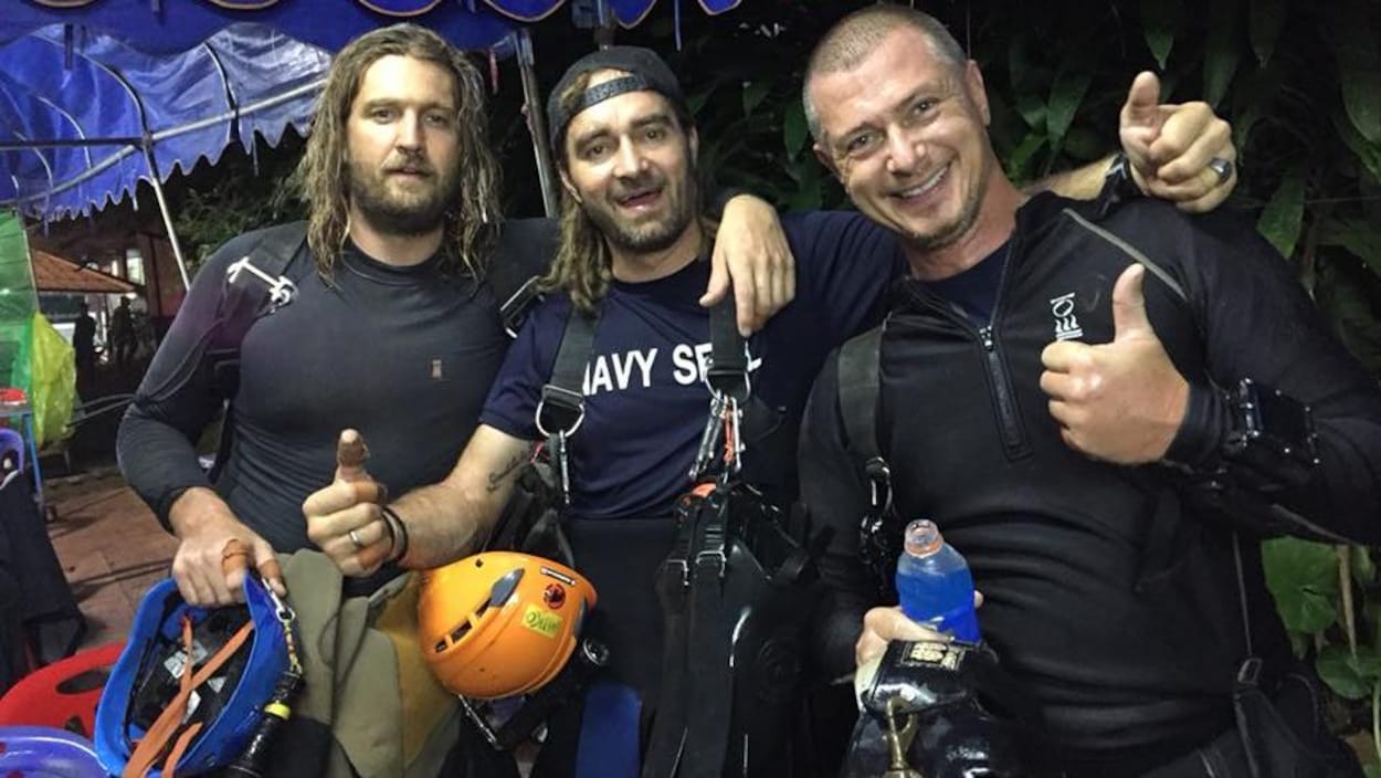Trois hommes en combinaison de plongée.