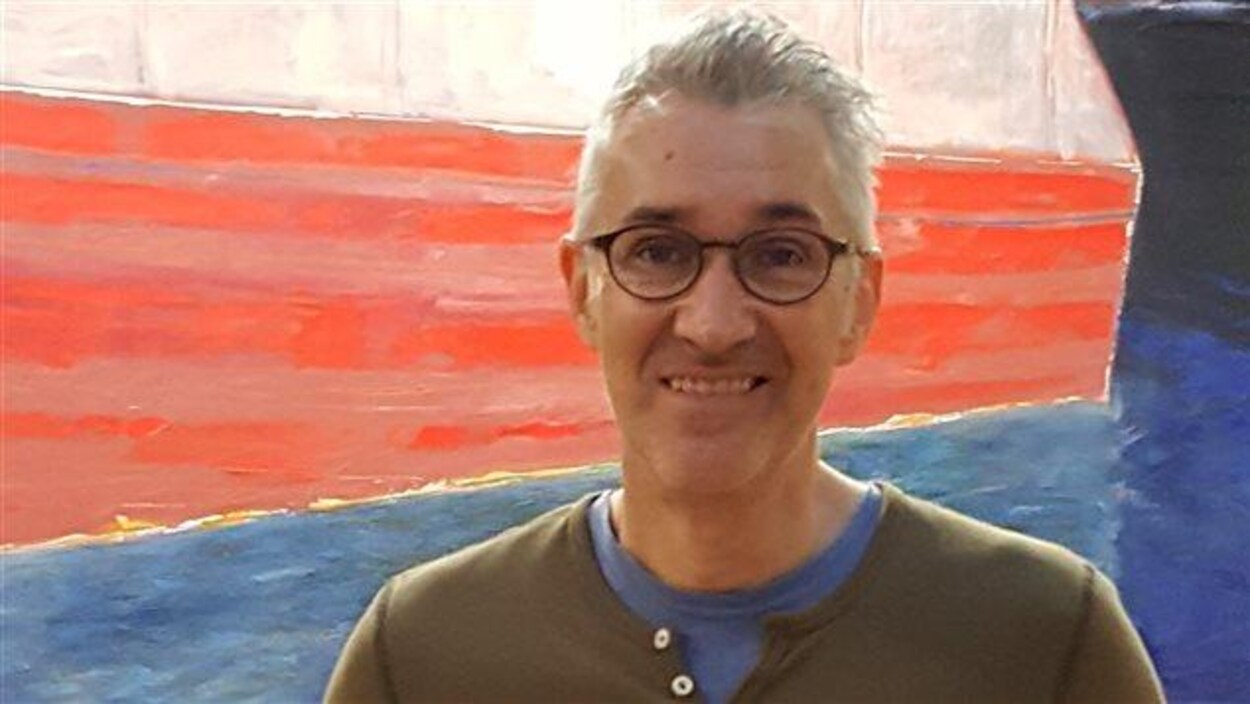 Erik Tremblay, souriant, regarde la caméra