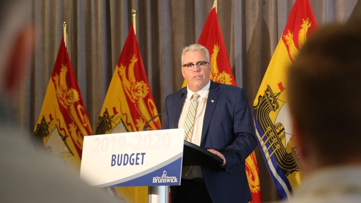 Ernie Steeves devant un lutrin sur lequel le mot « Budget » est écrit.
