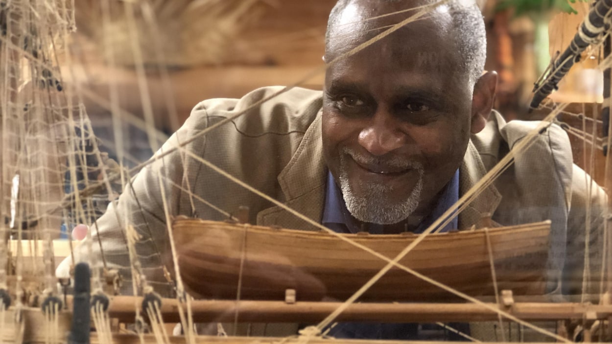 Dieudonné Boutrin regarde une maquette d'un navire négrier.