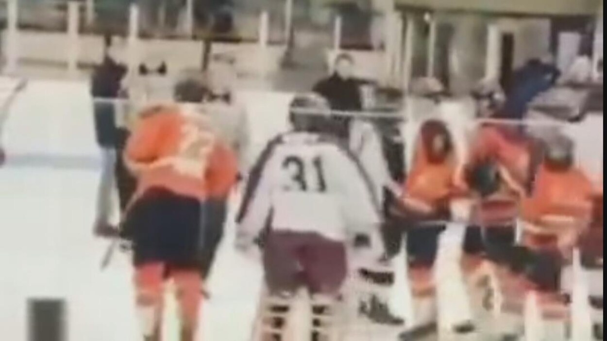 Des joueurs de hockey sur la glace dans un aréna.
