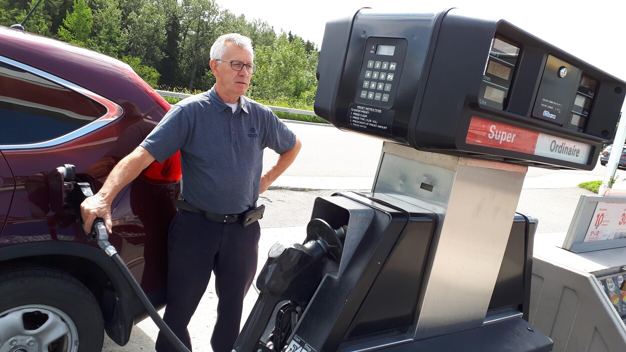 Alain Villeneuve met de l'essence dans sa voiture.