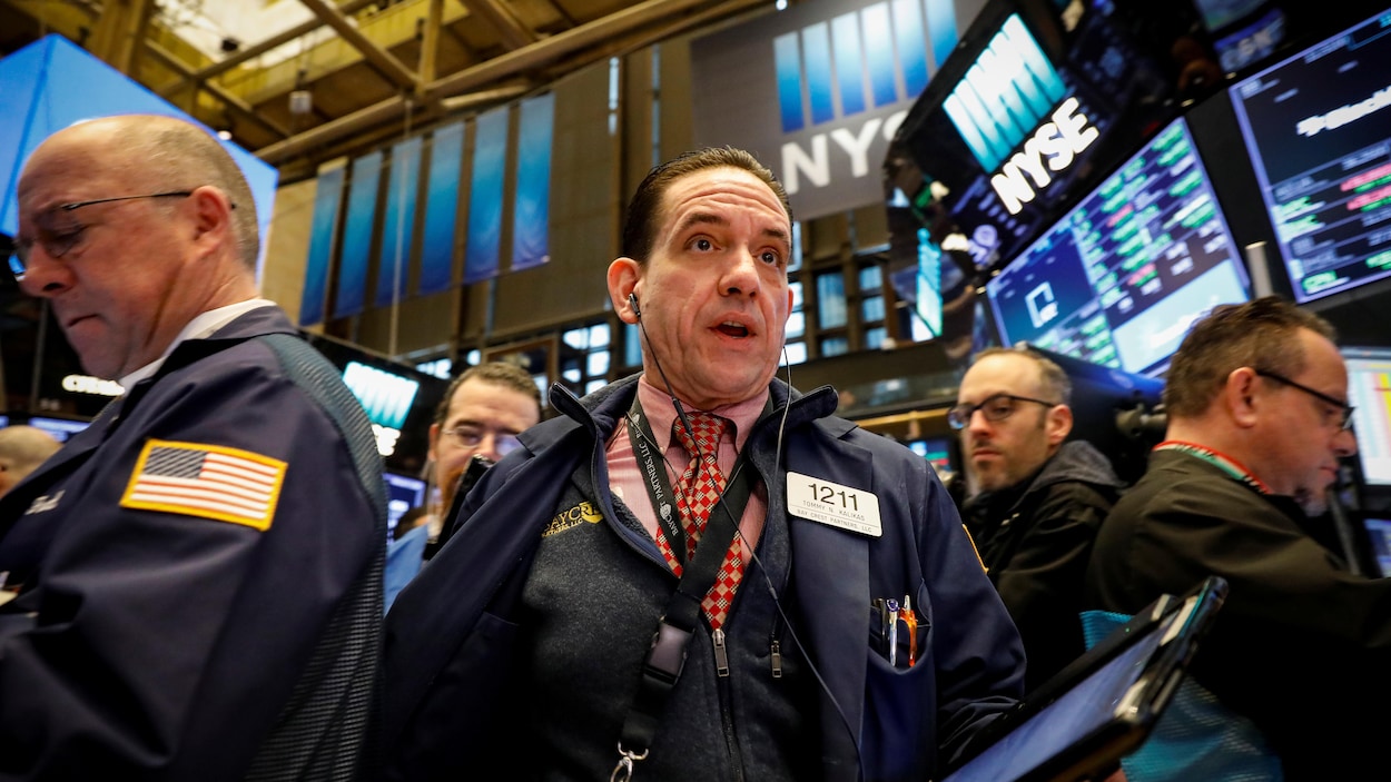 Des employés sur le plancher de la Bourse de New York. Des employés sur le plancher de la Bourse de New York.