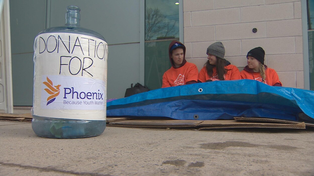 Trois étudiants dans la rue sous des toiles de plastique et des feuilles de carton Trois étudiants dans la rue sous des toiles de plastique et des feuilles de carton