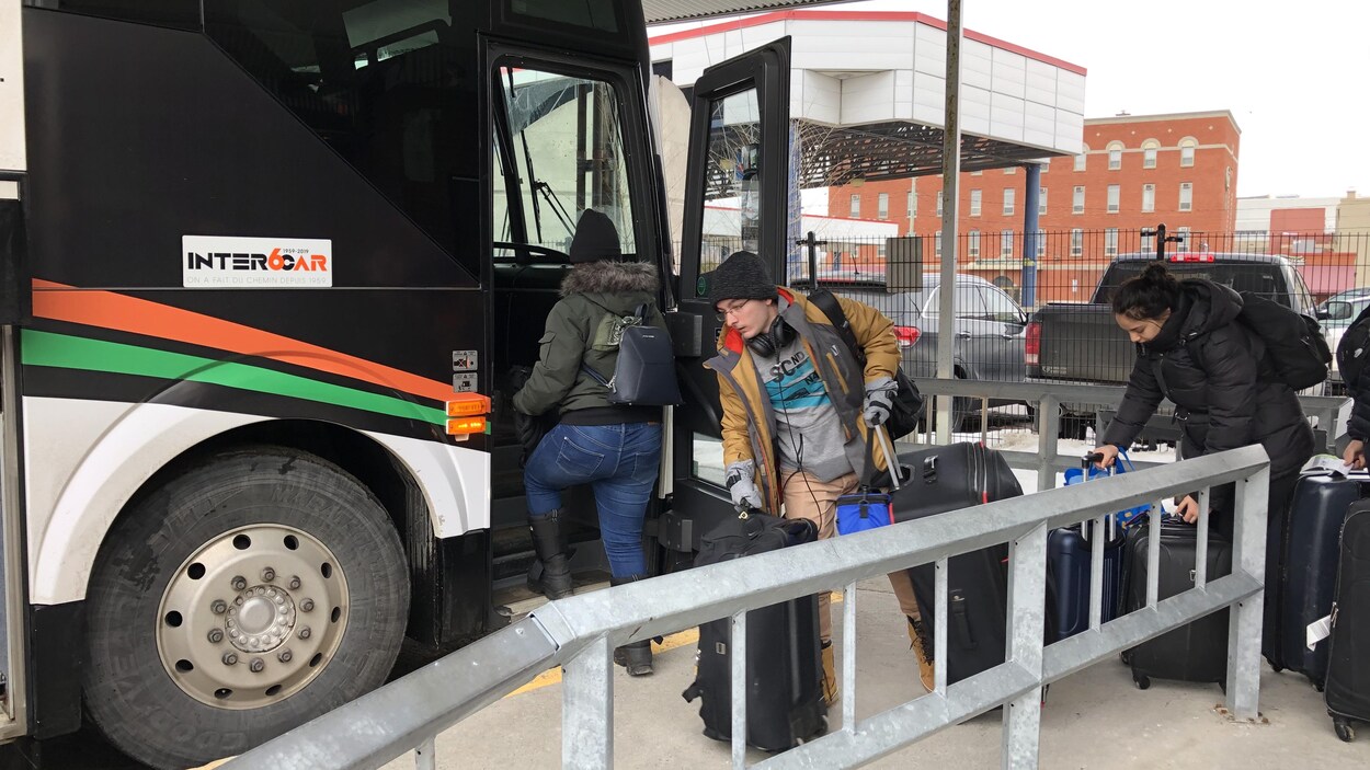 Des étudiants qui montent à bord d'un autobus d'Intercar.