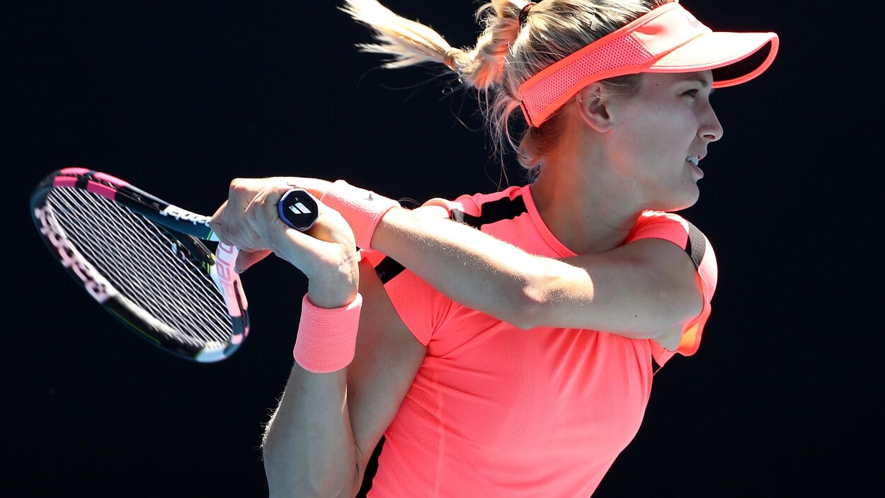 Vêtue entièrement de rose, Eugenie Bouchard tient sa raquette à deux mains. Vêtue entièrement de rose, Eugenie Bouchard tient sa raquette à deux mains.