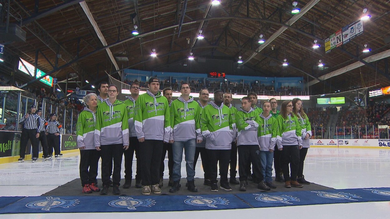 Un groupe de personnes au milieu d'une patinoire de hockey
