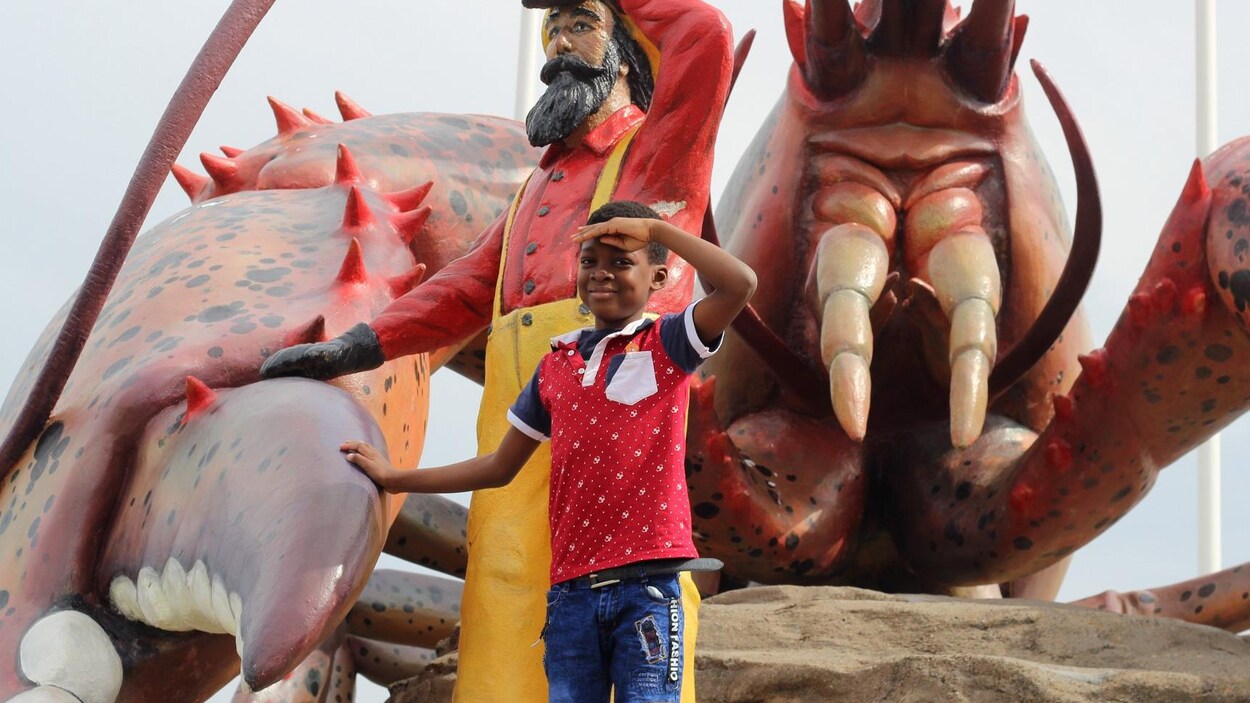 Euriel Ouedraogo, 7 ans, devant le homard géant à Shediac.