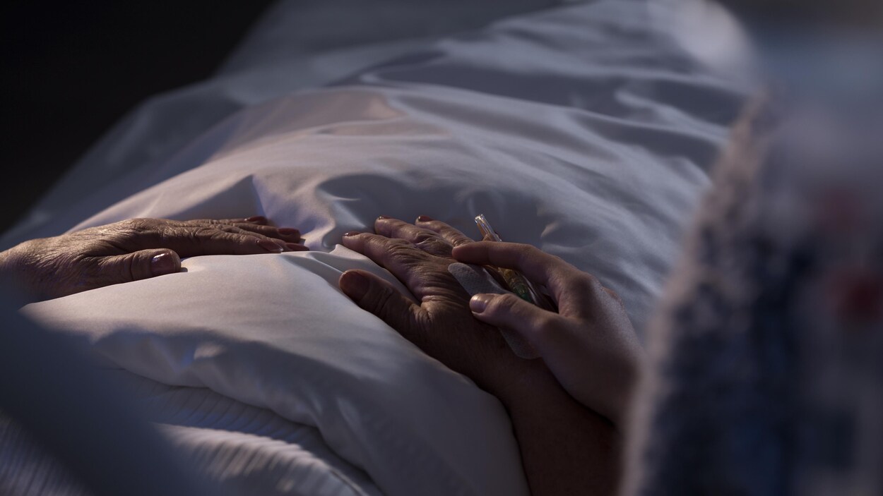 Une patiente en stade terminal accompagnée d'un membre de sa famille.