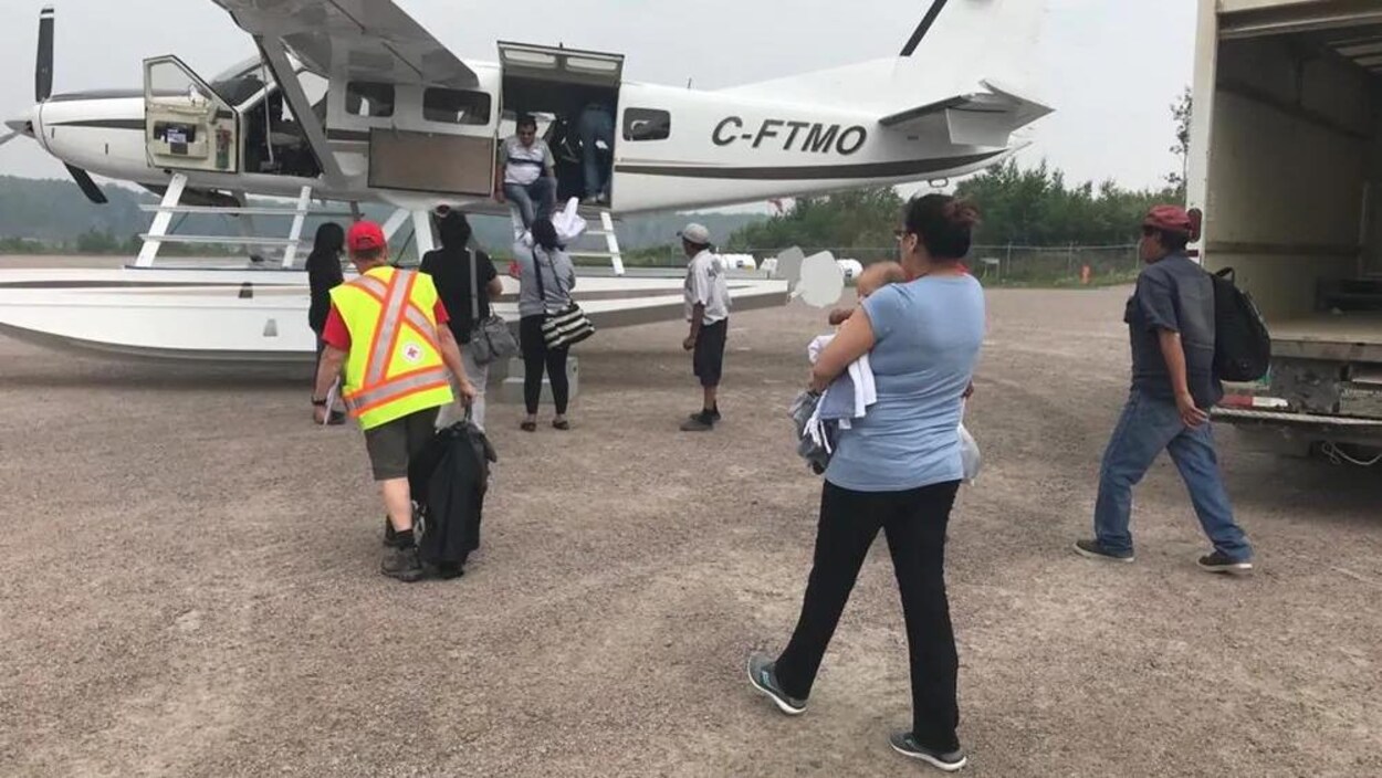 Des personnes s'apprêtent à monter à bord d'un petit avion