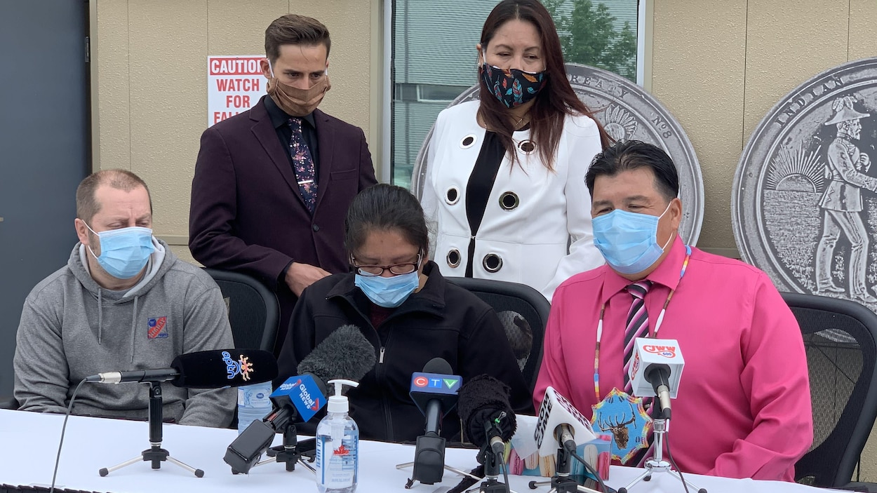 Cinq personnes portant un masque en conférence de presse.