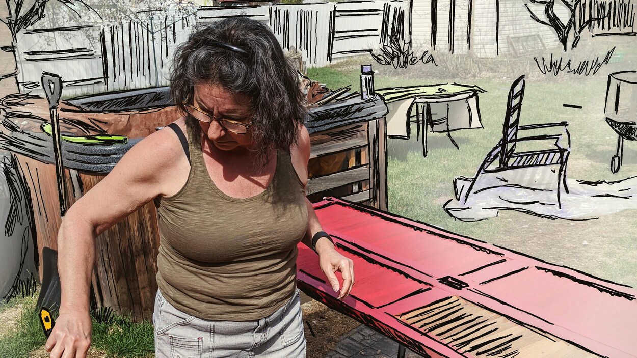 Ève Marie Forcier peinture une porte, dans sa cour-arrière.