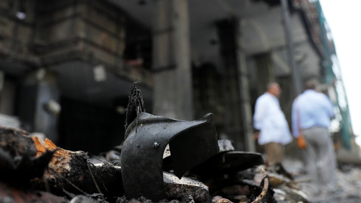 Des objets appartenant à des victimes au milieu des décombres devant la façade endommagée de l'Institut.
