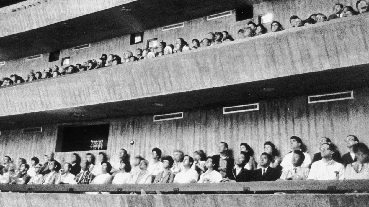 Des spectateurs regardent un film projeté dans un pavillon d'Expo 67. Des spectateurs regardent un film projeté dans un pavillon d'Expo 67.