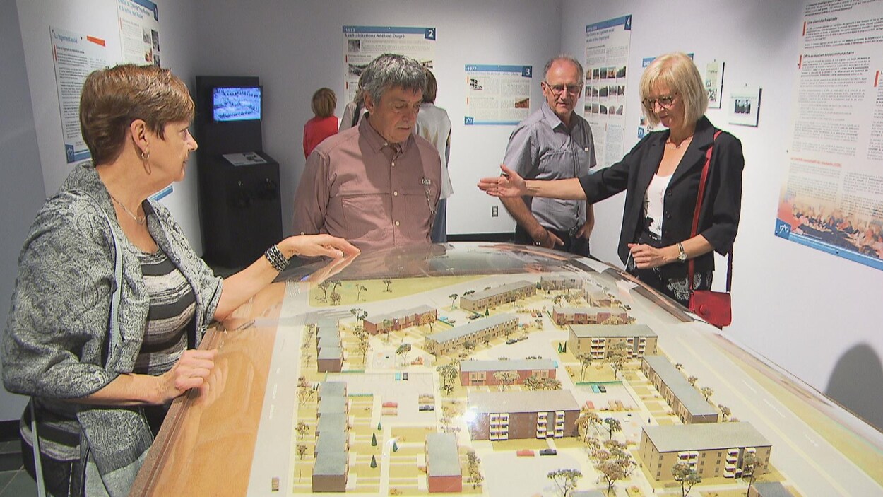 Des visiteurs observent la maquette d'un quartier