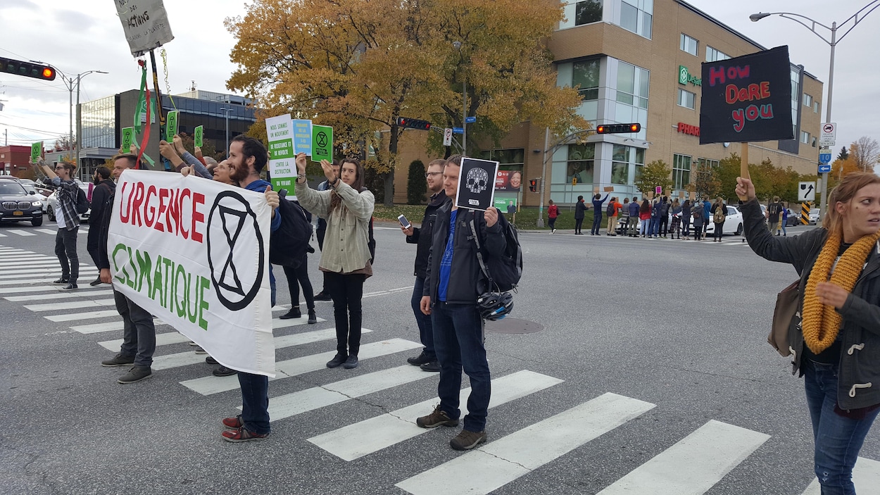 Des citoyens manifestent sur un passage piéton à Sherbrooke.